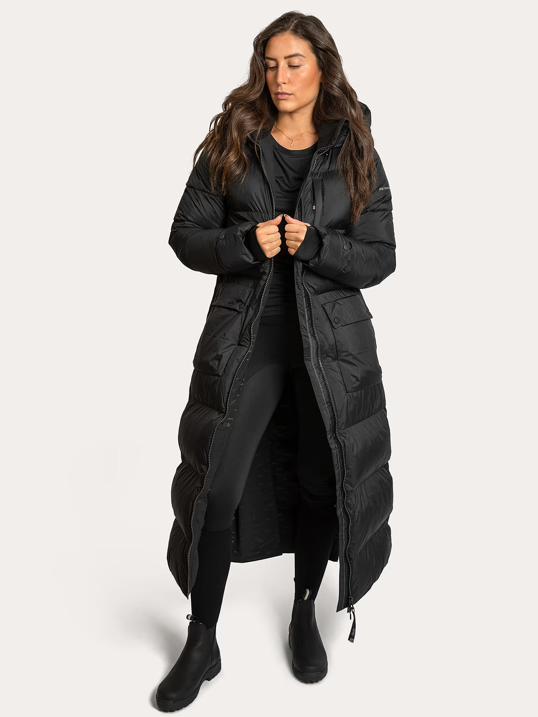 Woman wearing a Uhip arctic puffer coat extended Black on a white background
