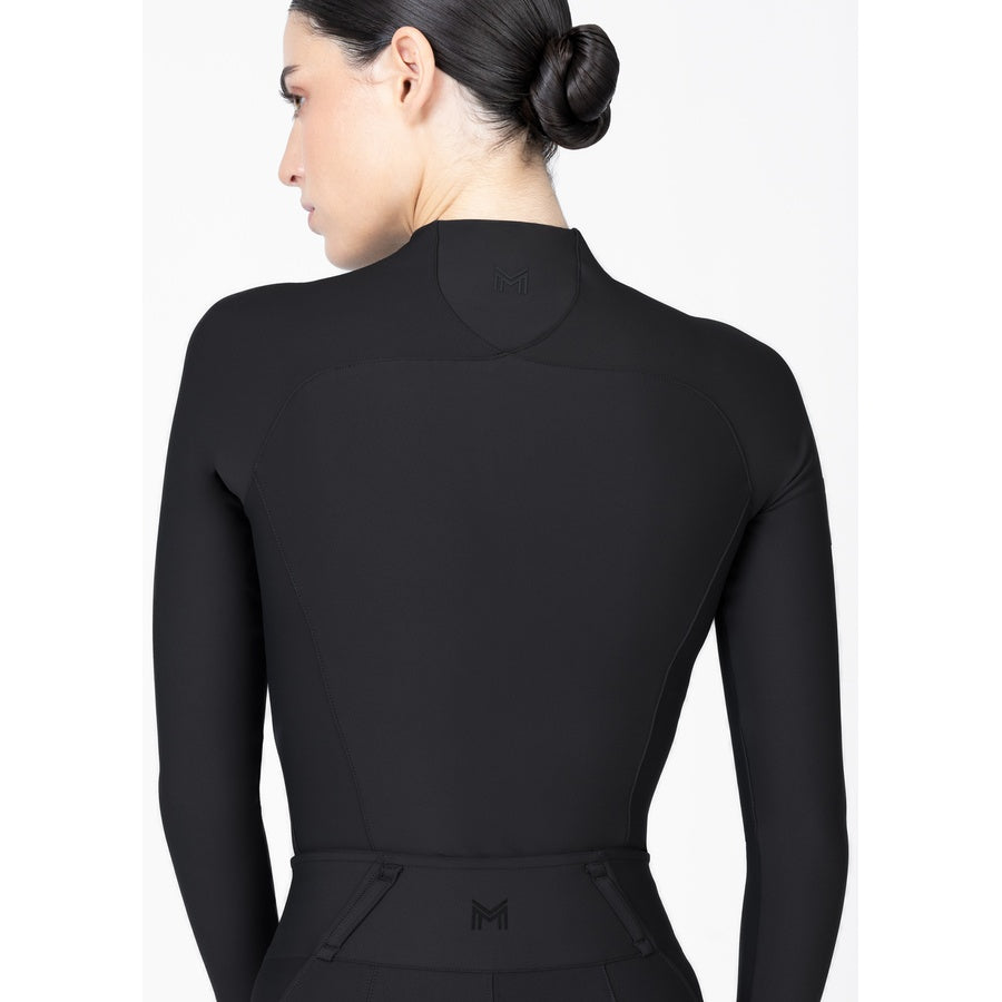 Side profile of women’s black long sleeve performance base layer designed for riding and training.