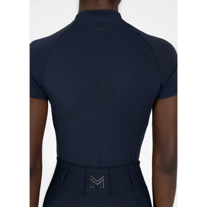 Model wearing black Maximilian Equestrian functional top on a white background, introducing the brand’s performance wear designed for movement in and out of the saddle.
