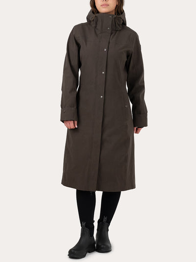A model wearing a Uhip Insulated ash brown raincoat with a button front, black tights, and black ankle boots, standing against a light off-white background.