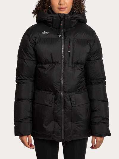 A woman wearing a Uhip Arctic Puffer Jacket Jet Black with a front zipper, zip chest pocket, and two large front flap pockets, photographed against a plain light background.