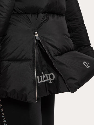 Close-up of a Uhip Arctic Puffer Jacket Jet Black with a front zipper, showing the reflective brand name 'uhip' printed in on the lower front and on the sleeve, against a light off-white background.