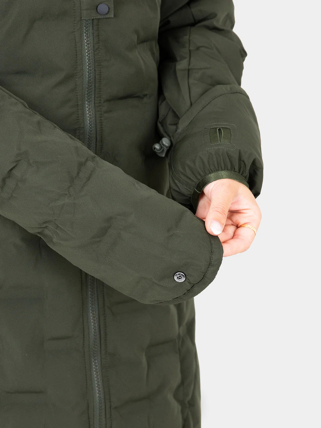 Close-up of a person wearing a Uhip Ice Coat in Dark Green  showing the sleeve, snap-button cuff, zipper, and hand against a light grey background.