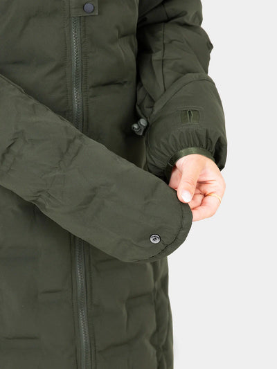 Close-up of a person wearing a Uhip Ice Coat in Dark Green  showing the sleeve, snap-button cuff, zipper, and hand against a light grey background.