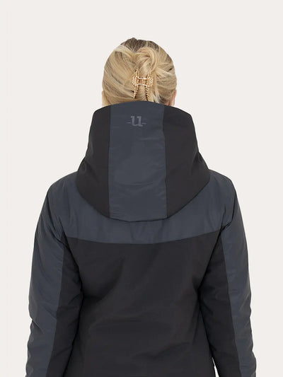 Rear view of a woman wearing a Uhip Reflective Jacket 2.0   against a light grey background.