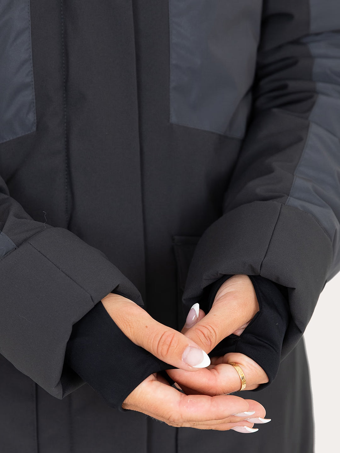 Close-up of a person wearing a  Uhip Reflective Jacket 2.0  with their hands folded together in front of the cuffs.