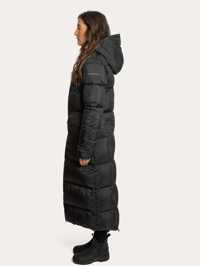 A woman shown in profile wearing a Uhip arctic puffer coat extended Black photographed against a plain light grey studio background.
